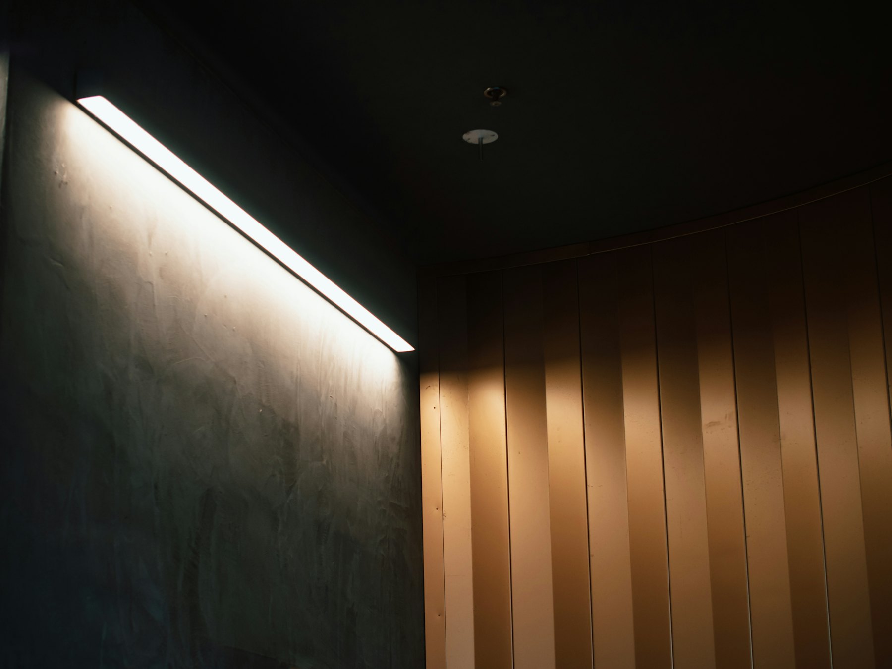 Linear light grazing a timber wall